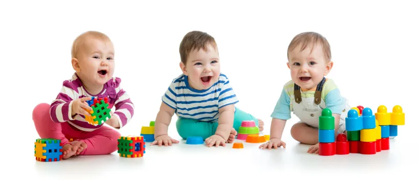 3 toddlers playing with blocks