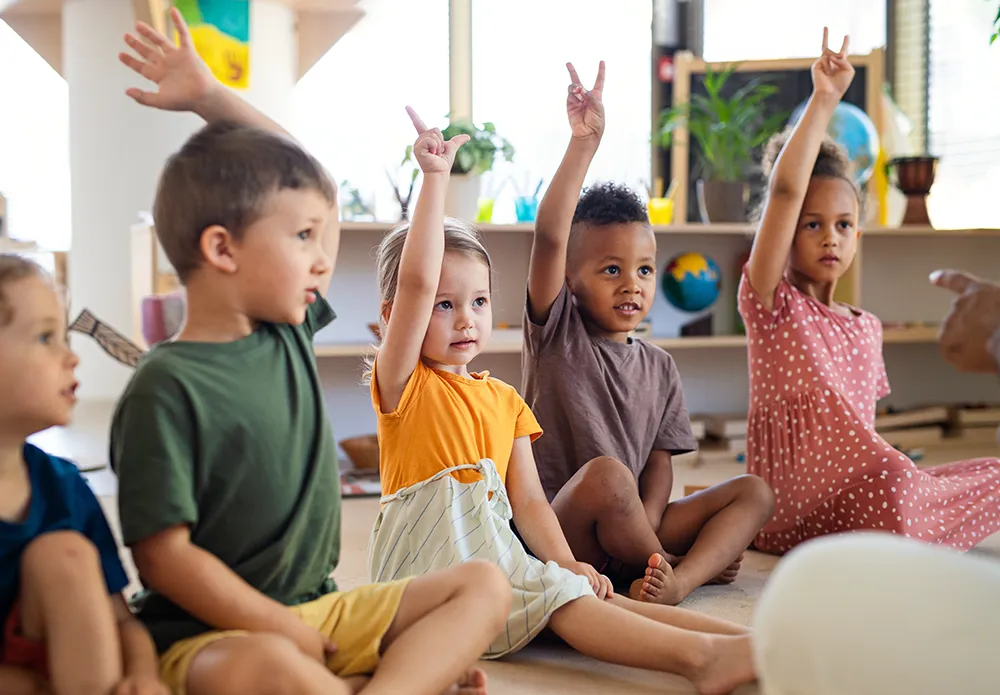 preschool children raising hands